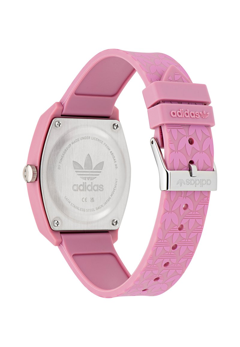 Orologio in silicone rosa con cassa esagonale, cinturino testurizzato con motivi floreali e retro in acciaio inossidabile. Logo Adidas sulla fibbia.