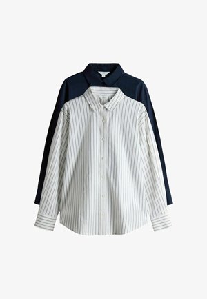 Två skjortor med långa ärmar och kragar, en vit med tunna vertikala svarta ränder och den andra mörkblå utan mönster, båda knäppta framtill.