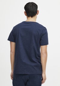 Námořnická modrá bavlněná tričko s krátkým rukávem, kulatým výstřihem, texturovaná látka s jemnými skvrnami a volný střih.