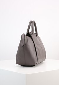 Grå läderhandväska med två topphandtag, en strukturerad form och subtila stygn detaljer. Slät textur med en minimalistisk design.