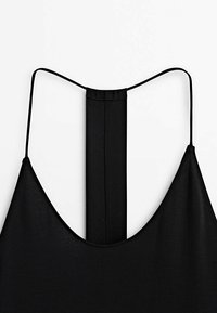 Robe noire sans manches avec fines bretelles et une sangle verticale courant le long du centre du dos sur un fond blanc.
