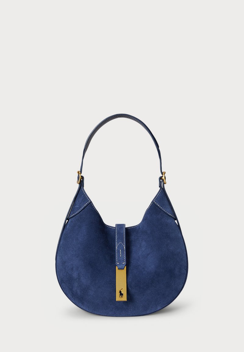 Jūras spēku zila zamšas rokassoma ar izliekta profilu, ar taisnu jostu, zelta aparatūru un centrālo tabulu detaļu.