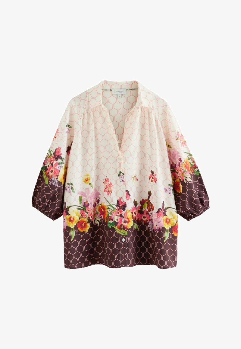 Blusa de mujer con botones, mangas tres cuartos, patrón de hexágonos en crema y marrón oscuro, y diseño de borde floral multicolor.