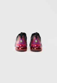 Μαύρα και ροζ αθλητικά παπούτσια με επάνω μέρος από δίχτυ, στρογγυλή φτέρνα και διαφανή κόκκινη σόλα με έντονη σήμανση στην φτέρνα.