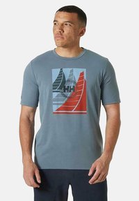 Camiseta gris de manga corta con un diseño gráfico de velero colorido en tonos de verde, rojo y azul, con un cuello redondo.