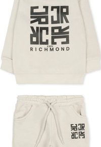 Jasno beżowy zestaw bluzy z kapturem i spodni dresowych z wyraźnym czarnym nadrukiem graficznym oraz logo. Wykonany z miękkiego materiału z elastycznym pasem.