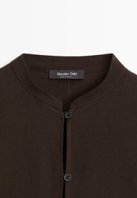 Bruine button-up shirt met een ronde halslijn, voorste knoopsluiting en twee zwarte knopen. Het label zegt "Massimo Dutti," met stiksels details.