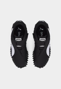 Αθλητικά παπούτσια Puma σε ασπρόμαυρο με λουριά Velcro, υφασμένη σόλα και πάτο Ortholite, φαίνονται από πάνω σε απλό φόντο.