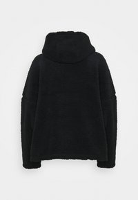 Abrigo exterior negro de forro polar con capucha, que presenta una superficie texturizada, hombros caídos y un ajuste holgado. No tiene cierres visibles ni patrones.