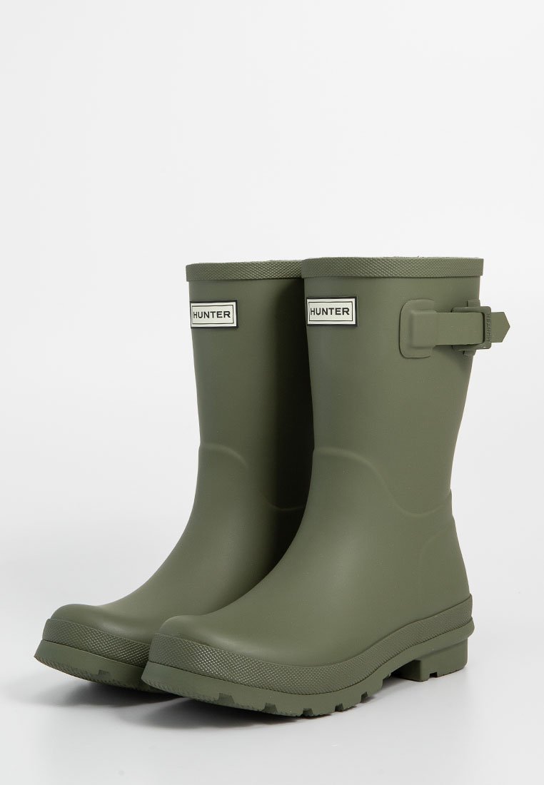 Par de botas de goma impermeables de color verde olivo de la marca Hunter, con correas laterales ajustables y suelas texturizadas.