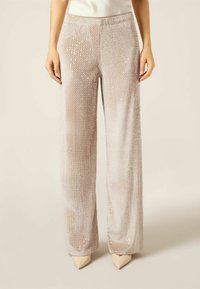 Světle růžové široké kalhoty se zelen�ým flitrovým povrchem a jemným leskem, s hladkým pasem a plnou délkou.