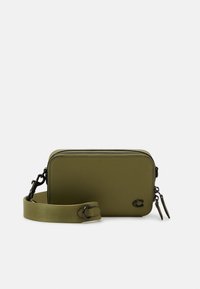 Borsa a tracolla verde oliva realizzata in pelle texturizzata, con chiusura a zip, tracolla regolabile e un sottile accento con logo sul davanti.