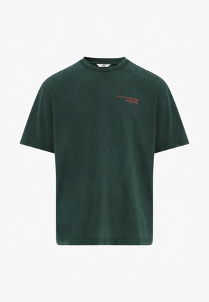 Tamnozeleni pamučni majica kratkih rukava s okruglim izrezom. Ima crveni natpis sprijeda. Glatka tekstura i opušteni kroj.