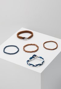 Ensemble de cinq bracelets : tressé brun, perles de bois claires et foncées, en perles bleues, et un design tressé bleu et blanc avec des accents métalliques.