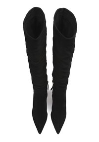 Par de botas altas de ante negro con puntas afiladas y cañas arrugadas, vistas desde arriba sobre un fondo blanco.