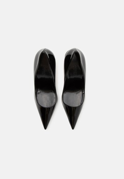 Pantofi cu toc înalt din piele lacuită neagră, cu un design cu vârful ascuțit, prezentând o textură netedă și un stil minimalist.