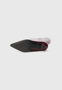 Bordo krāsas augstpapēžu kurpes ar smailu purngalu, izgatavotas no teksturētas mākslīgās ādas ar melnu gumijas zolīti. Uz augšdaļas redzamas izteiktas ribotas detaļas.