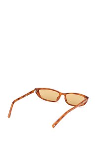 Ruske tortoiseshell sunčane naočale s oštrim dizajnom, smešnim lećama i tankim okvirom s malim srebrnim detaljima.