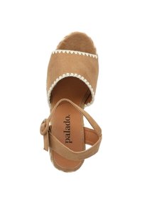 Bruine suède espadrille met een gegolfde rand, open teen en enkelbandje met een knoopsluiting en een gestructureerde binnenzool.