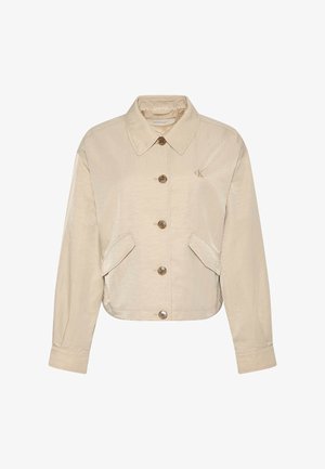 Beige cropped jakke med lange ærmer, knaplukning foran, to klaplommer, spids krave og lille broderet "cK" logo på brystet.