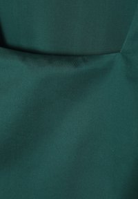 Dark teal fabric with a smooth texture, featuring a folded design and subtle sheen. No visible patterns or hardware details.