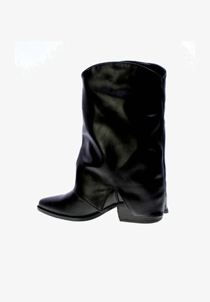 Bottine en cuir noire mi-mollet avec un petit talon empilé et un bout légèrement pointu, montrée du côté intérieur.