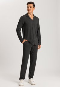 Hiilenharmaa pyjama-asukokonaisuus, jossa on pitkät hihat, nappikiinnitys ja vastaavat housut. Pehmeä, kevyt kangas; paidassa on kaulus ja rintatasku.