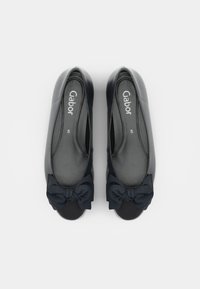 Chaussures plates en cuir noir avec bouts arrondis, nœuds en tissu à l’avant et marquage "Gabor" à l’intérieur, vues de dessus sur fond blanc.