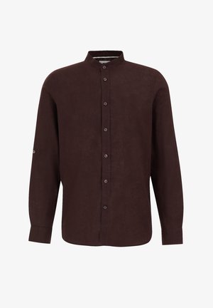 Brūna krekla ar pogām, ar apļa apkakli, garām piedurknēm un pogājamiem aproces galiem. Izgatavots no teksturētas auduma, ar maigu spīdumu.