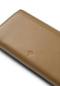 Bruine leren portemonnee met een gestructureerde oppervlakte en subtiele embossing van een bladmotief. Heeft afgeronde hoeken en gestikte details.