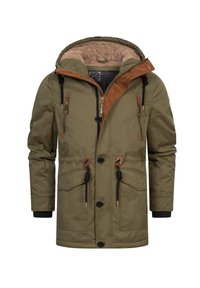 Giacca invernale verde oliva con rifiniture in velluto a coste marrone, cappuccio foderato in pile, lacci neri, tasche frontali con zip e chiusura frontale con bottoni.