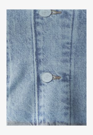 Heled sinises denimit kangas, millel on kaks esist doput ja vertikaalsed õmblused. Tekstuur on veidi kulunud ja värviparandused on peened.