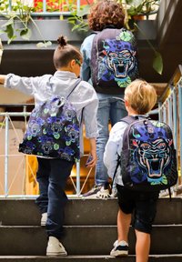 Rugzakken met levendige tijgermotieven in blauw, groen en paars, gemaakt van duurzame stof. Kinderen stijgen de trap op, gekleed in casual kleding.