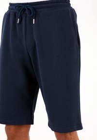 Pantaloni sportivi blu navy realizzati in cotone misto, con vita elastica e stringa di regolazione, tasche laterali e una finitura liscia.