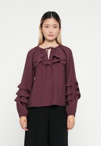 Bordeaux blouse met gerimpelde voorkant en mouwen, lichtgewicht stof, lange mouwen met gathered manchetten, strikdetails bij de halslijn, en een relaxte pasvorm.