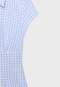 Robe à manches courtes bleu clair et blanche avec un motif à carreaux et une taille froncée, présentée sur un fond uni.