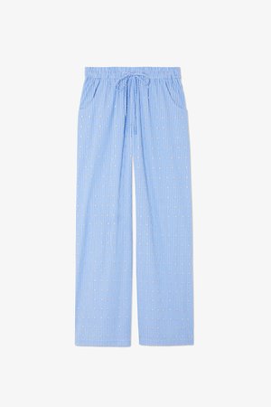 Blauwe pyjamabroek met een verticale gestreepte print en kleine geometrische ontwerpen. Voorzien van een elastische tailleband met een trekkoord en zijzakken.
