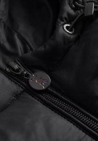 Zwarte gewatteerde jas met een glanzende textuur, voorzien van een ritssluiting en een ronde ritstrekker met een logo. Inclusief verstelbare koorddetails.