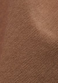 Brązowa tkanina bawełniana o teksturowanym, tkanym wzorze, prezentująca miękkie, matowe wykończenie i subtelne różnice w odcieniu.
