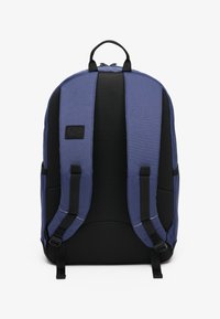Mochila azul y negra con un acabado de tela suave, panel de malla y correas de hombro ajustables y acolchadas. Cuenta con un parche de marca en la parte frontal.