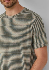 Gestreiftes T-Shirt aus weichem Stoff; verfügt über horizontale Linien in sanften Blau- und Beigetönen; runder Ausschnitt und kurze Ärmel.