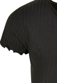 Haut noir côtelé à manches courtes avec bords festonnés et col en V, montrant la texture du tissu et de fines lignes verticales.