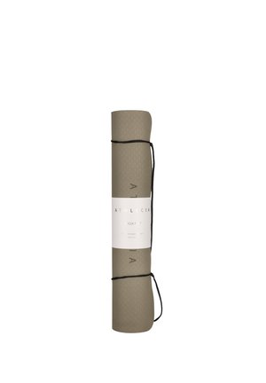 Opgerolde beige yogamat, vastgemaakt met zwarte banden en een witte labelband met productbranding en tekst.