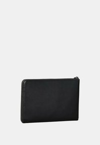 Pochette en cuir noir avec une texture lisse, de forme rectangulaire et une fermeture éclair sur le bord supérieur. Design minimaliste.