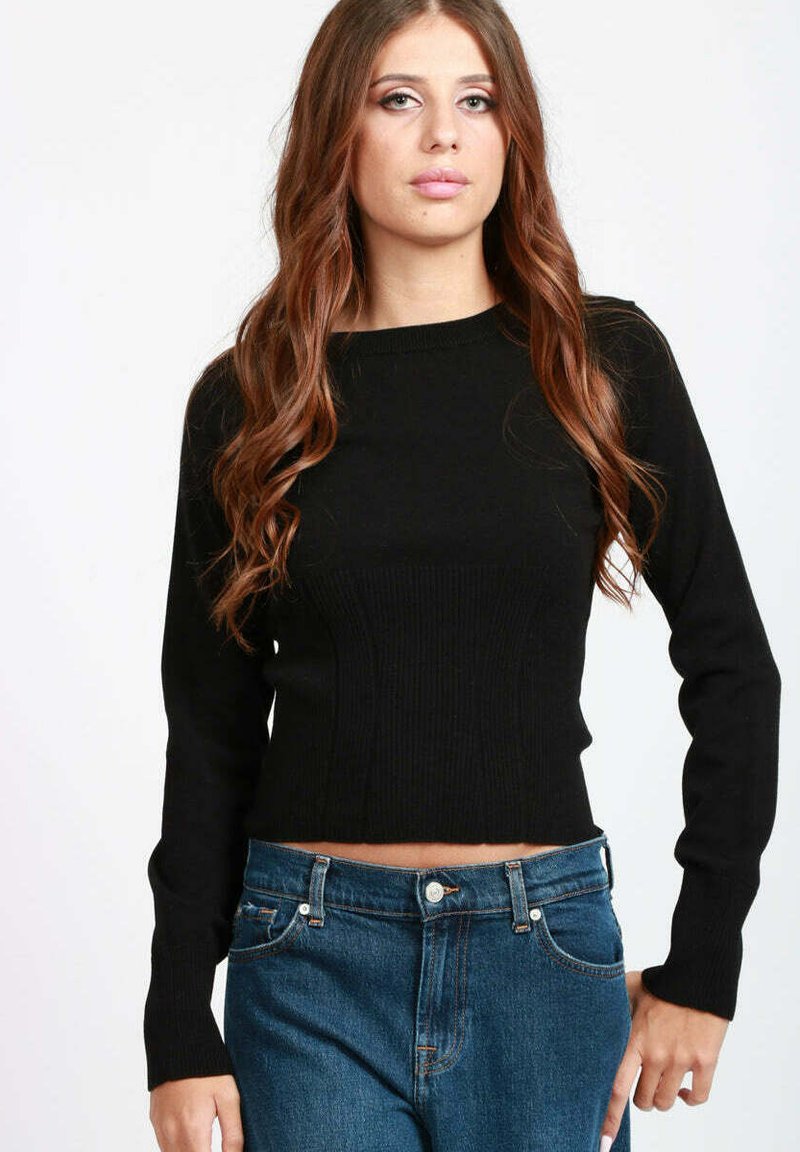Maglione corto nero a costine con maniche lunghe e scollatura rotonda, abbinato a jeans in denim a vita alta. Texture liscia con design aderente.