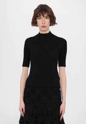 Top nero a coste con maniche corte, scollo alto e silhouette aderente, abbinato a una gonna floreale nera con texture.