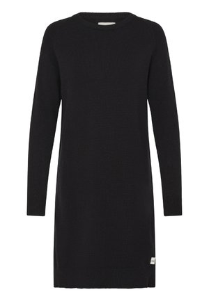 Zwarte gebreide jurk met lange mouwen, een ronde hals en een klein wit labeltje aan de zoom aan de rechterkant.