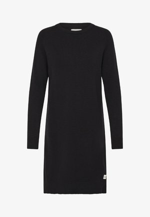 Zwarte gebreide jurk met lange mouwen, een ronde hals en een klein wit labeltje aan de zoom aan de rechterkant.
