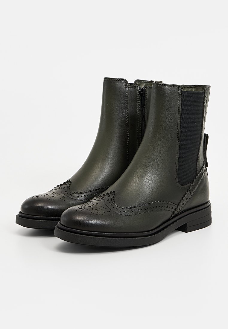 Groene leren enkellaarsjes met brogue-details, elastische zijpanelen en een platte zool. Voorzien van een ritssluiting en gestructureerde accenten.