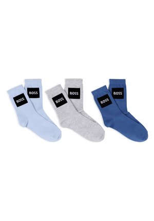 Quattro paia di calzini in azzurro chiaro, grigio e blu navy. Ognuno presenta un'etichetta rettangolare nera con la scritta "BOSS" in bianco. Materiale in cotone.